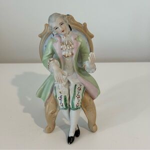 Vintage hand-painted porcelain figurine of a seated man in 18th-century attire